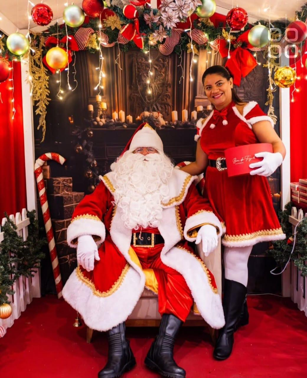 Papai Noel e Noelete em cenário decorado de Natal